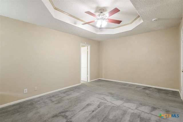 unfurnished room featuring carpet floors, baseboards, a tray ceiling, and a textured ceiling