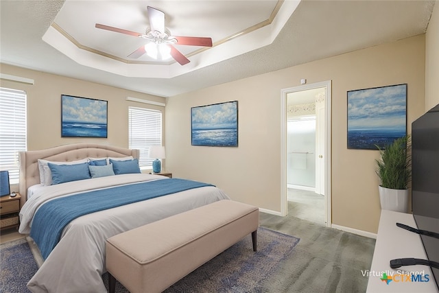 bedroom with ceiling fan, carpet flooring, a raised ceiling, and baseboards