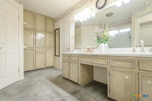 bathroom with double vanity, carpet, a sink, and wallpapered walls