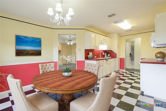 dining room with visible vents, light floors, and ceiling fan with notable chandelier