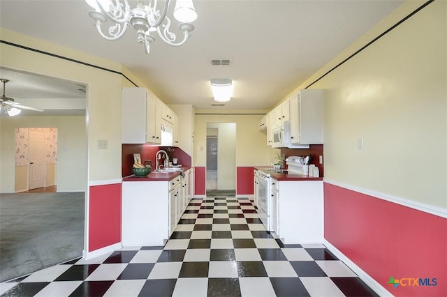 kitchen with white appliances, dark floors, white cabinets, and a sink