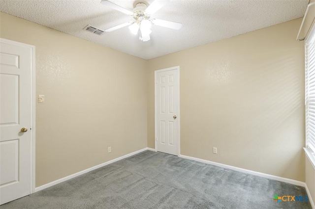 carpeted empty room featuring a ceiling fan, baseboards, visible vents, and a textured ceiling