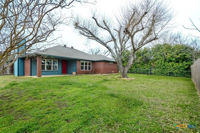 exterior space with fence private yard, brick siding, and a front lawn