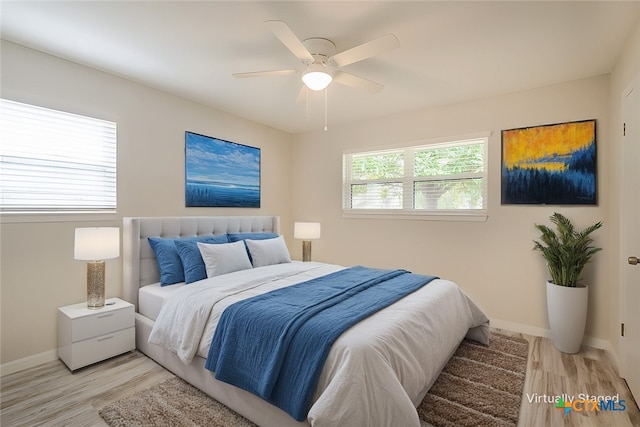 bedroom with multiple windows, ceiling fan, and light hardwood / wood-style flooring