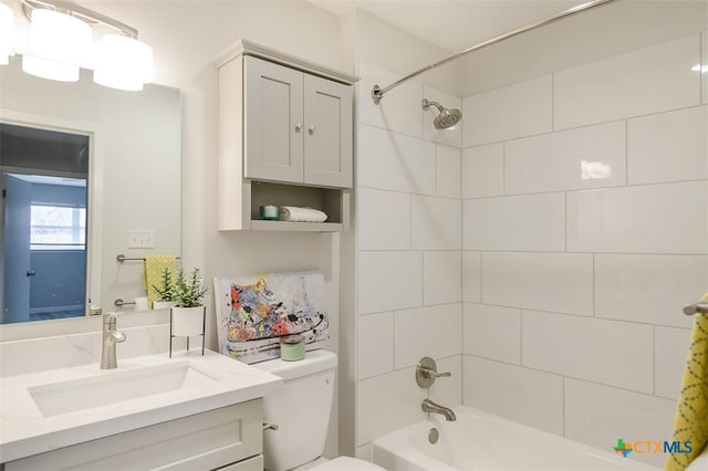 full bathroom with tiled shower / bath, vanity, and toilet