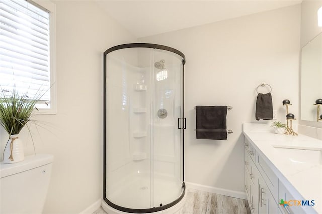 bathroom featuring vanity, hardwood / wood-style flooring, toilet, and walk in shower