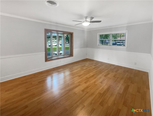 empty room featuring ceiling fan, wood-type flooring, plenty of natural light, and ornamental molding