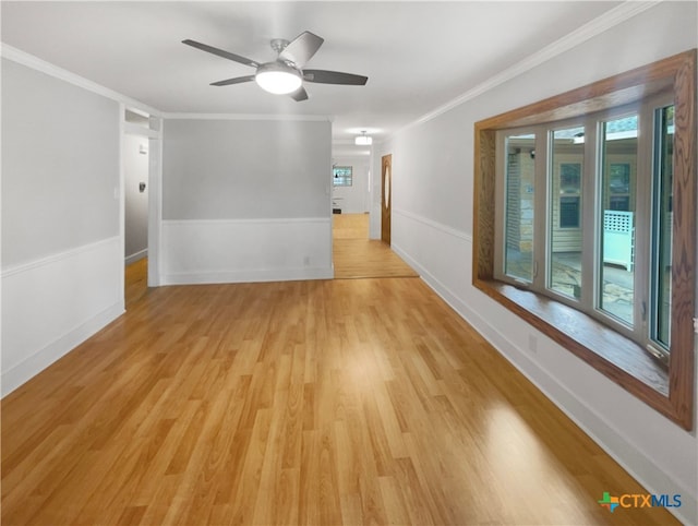 empty room featuring ceiling fan, light wood-type flooring, and ornamental molding