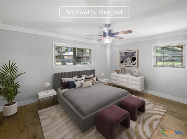 bedroom featuring ceiling fan, light hardwood / wood-style flooring, and ornamental molding