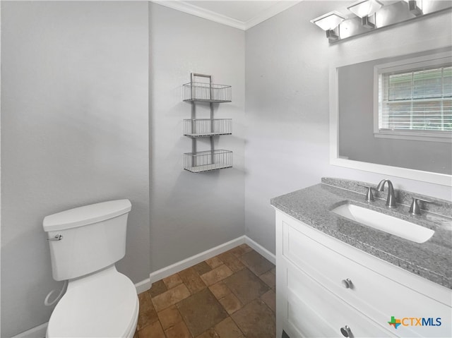 bathroom with toilet, vanity, and crown molding