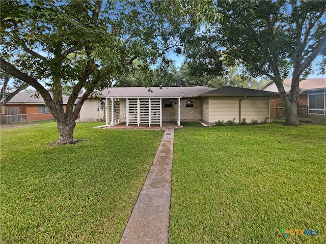 ranch-style home with a front yard and a patio area