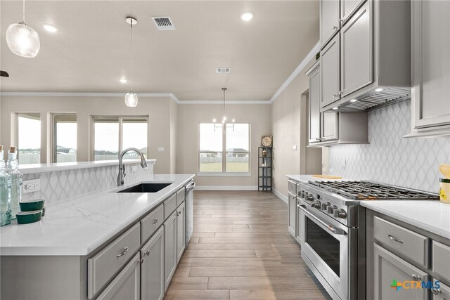 kitchen featuring gray cabinets, light stone counters, and stainless steel appliances