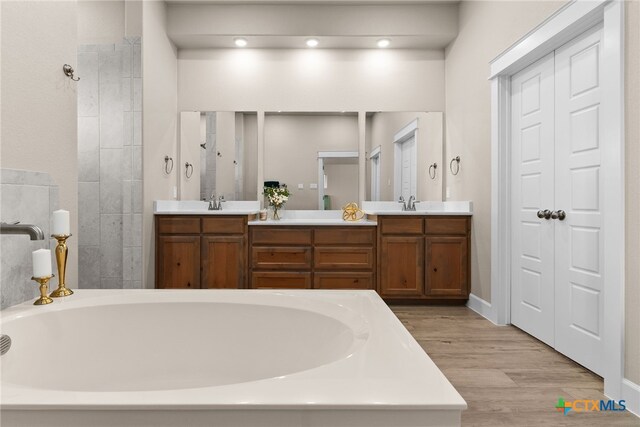 bathroom with shower with separate bathtub, vanity, and hardwood / wood-style floors