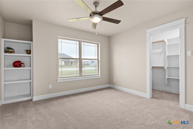 unfurnished bedroom with connected bathroom, light carpet, and ceiling fan