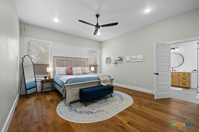 bedroom with multiple windows, wood-type flooring, connected bathroom, and ceiling fan