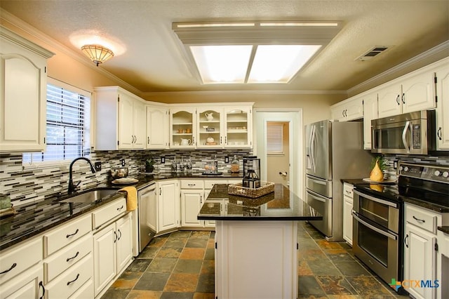 512 Gazelle Trl, Harker Heights, TX 76548 - kitchen with appliances with stainless steel finishes, ornamental molding, tasteful backsplash, stone tile floors, and a center island