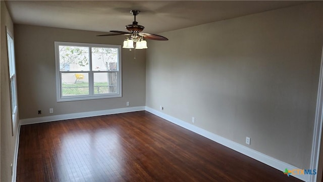 empty room with ceiling fan and dark hardwood / wood-style flooring