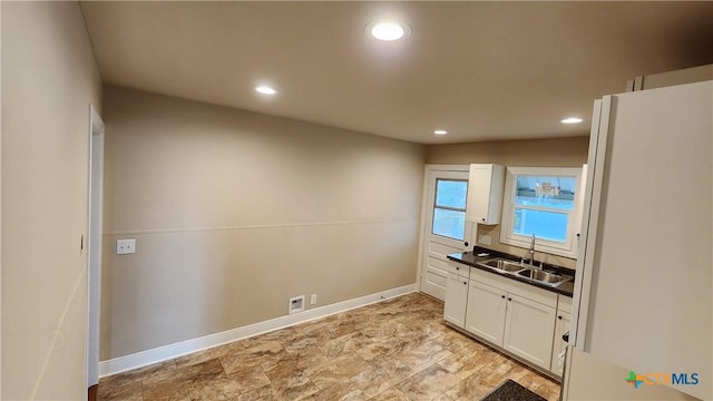 interior space featuring white cabinets and sink