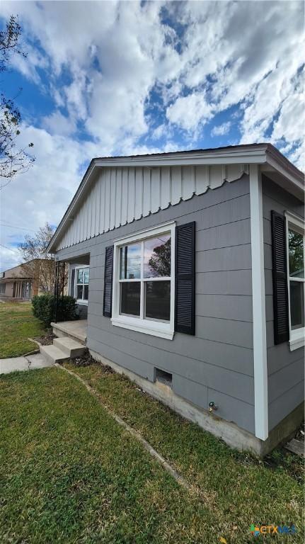 view of side of home featuring a lawn