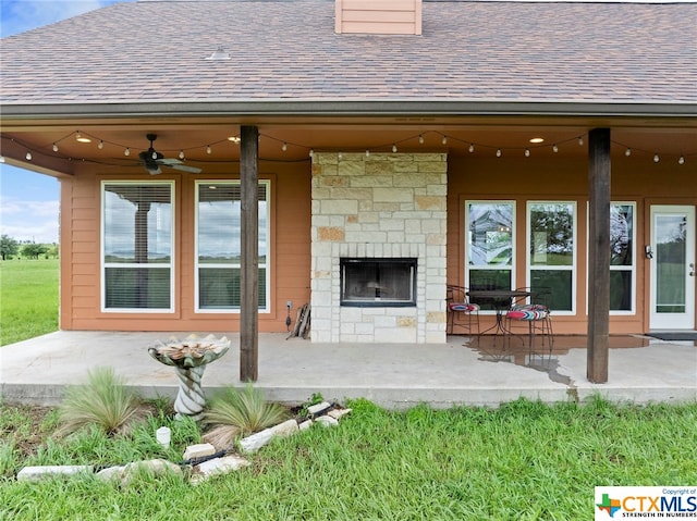 view of patio / terrace featuring an outdoor stone fireplace and ceiling fan