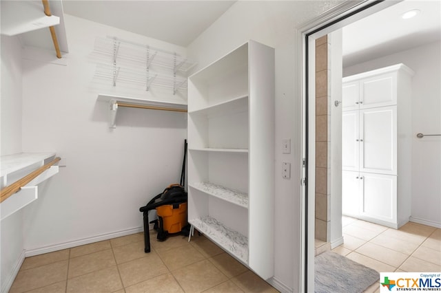 walk in closet with light tile patterned floors