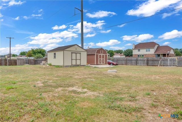 view of yard featuring a storage unit, an outdoor structure, and a fenced backyard