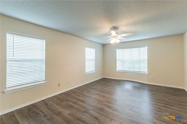 empty room with dark wood-type flooring, ceiling fan, a textured ceiling, and baseboards