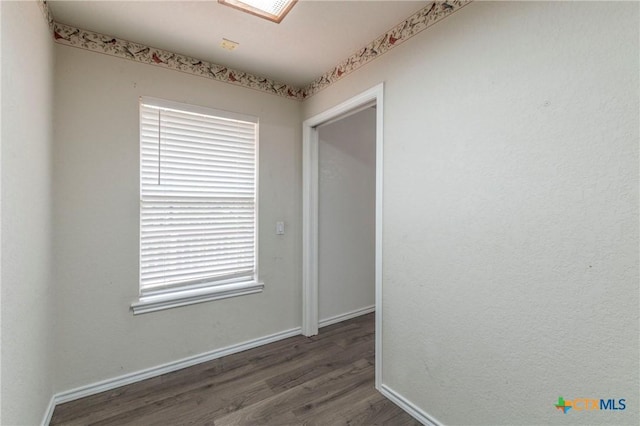 empty room featuring wood finished floors and baseboards