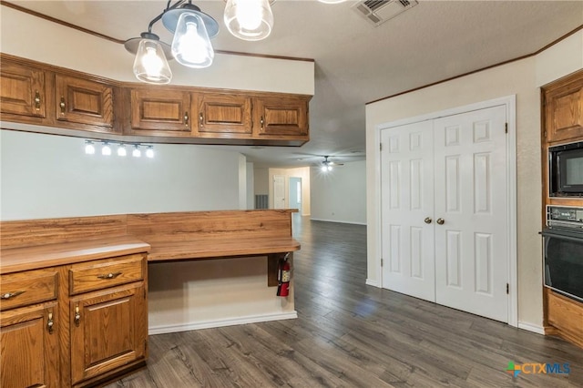 kitchen with visible vents, dark wood-style floors, butcher block counters, brown cabinets, and black appliances