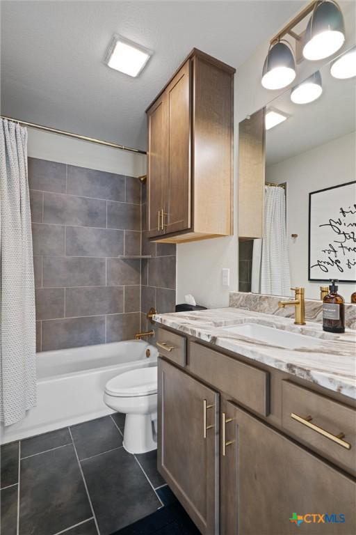 bathroom with vanity, toilet, tile patterned floors, and shower / tub combo