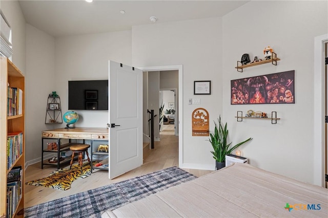 bedroom with baseboards, wood finished floors, and a baseboard radiator