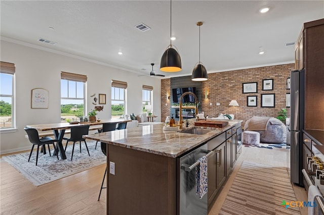 kitchen with visible vents, open floor plan, a sink, and stainless steel appliances