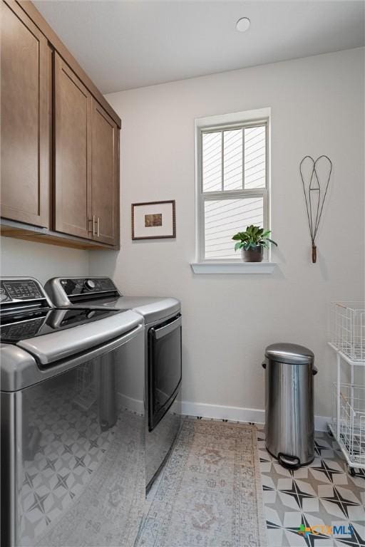 laundry area with cabinet space, independent washer and dryer, and baseboards