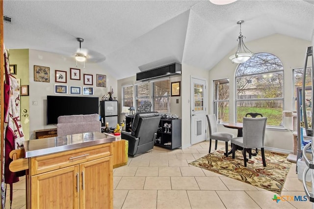 tiled office space with ceiling fan, a textured ceiling, and vaulted ceiling