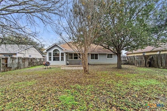 rear view of house featuring a sunroom and a patio