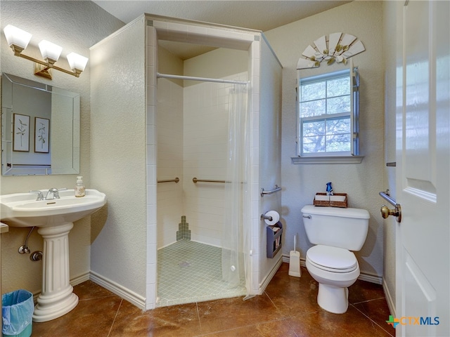 bathroom featuring toilet, a shower with curtain, and tile patterned floors