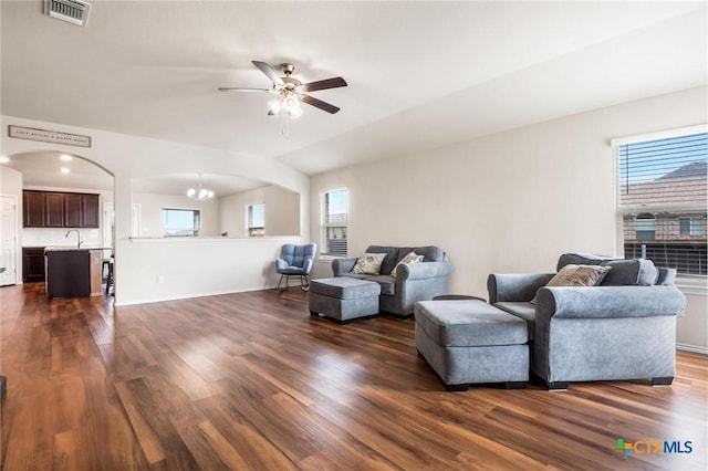 living room with ceiling fan, dark wood-style floors, plenty of natural light, and arched walkways