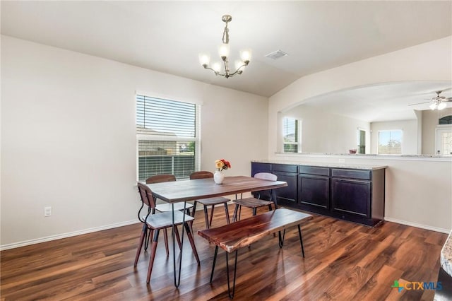dining space featuring a chandelier, dark wood-style flooring, arched walkways, a ceiling fan, and baseboards