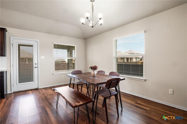 dining area featuring a chandelier, dark wood-style floors, baseboards, and vaulted ceiling
