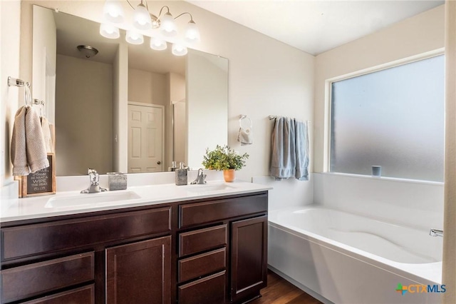 bathroom featuring a garden tub, double vanity, and wood finished floors