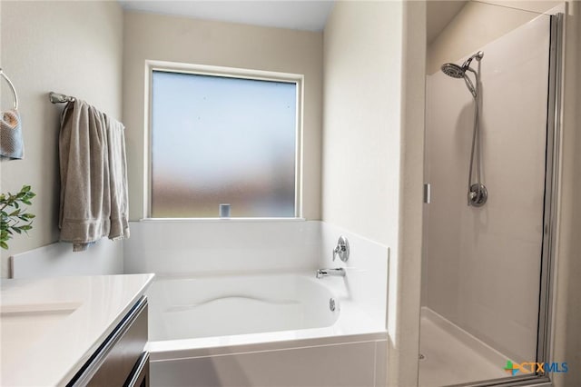 bathroom featuring a stall shower, a garden tub, and vanity