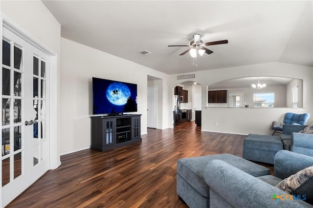 living area with arched walkways, dark wood-style floors, a ceiling fan, and a chandelier