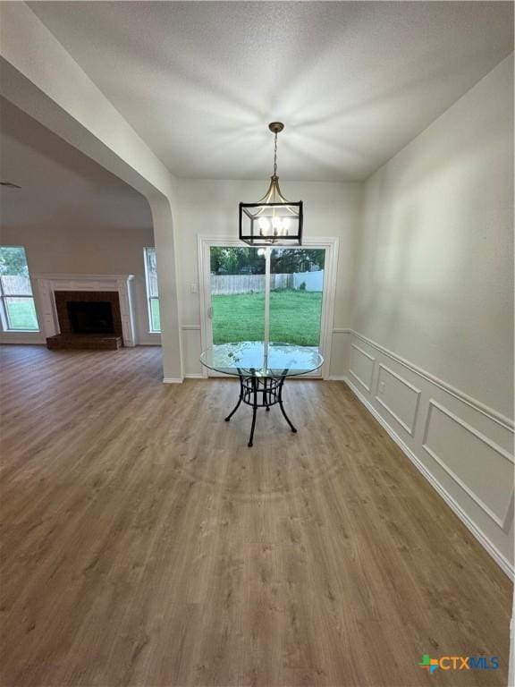 500 Chickasaw Dr, Harker Heights, TX 76548 - unfurnished dining area featuring a decorative wall, wood finished floors, a chandelier, a wainscoted wall, and arched walkways