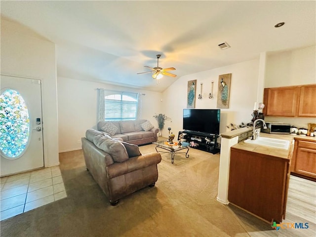 living room with ceiling fan, light tile patterned floors, lofted ceiling, and sink