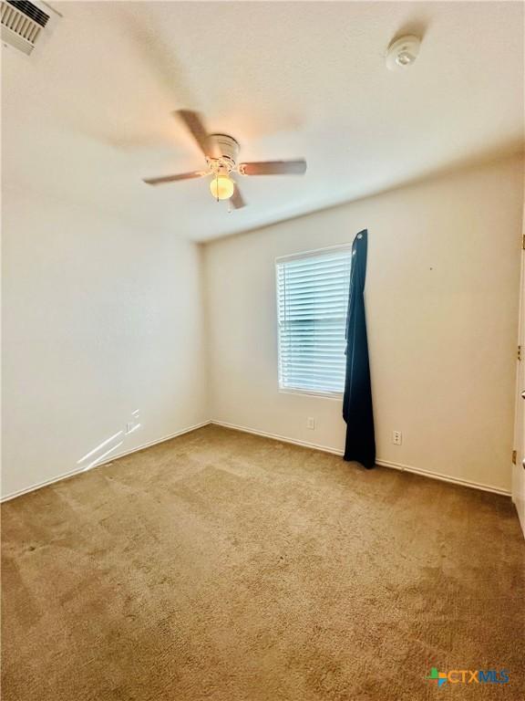 carpeted spare room with ceiling fan