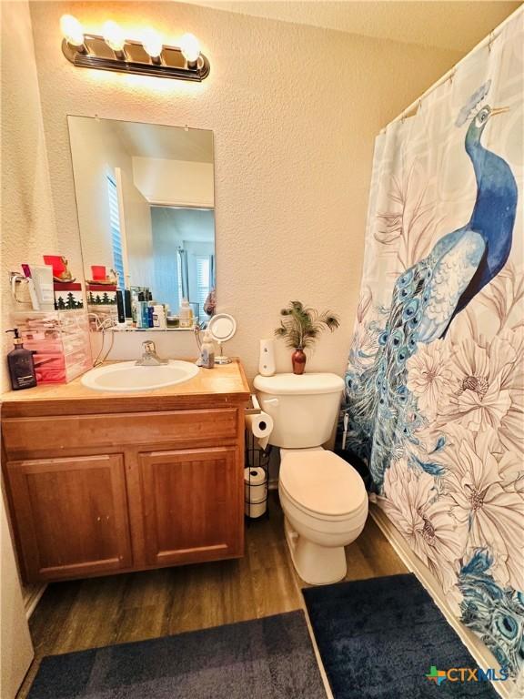 bathroom with hardwood / wood-style flooring, toilet, and vanity