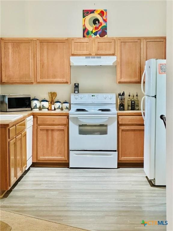 kitchen with white appliances and light wood-type flooring