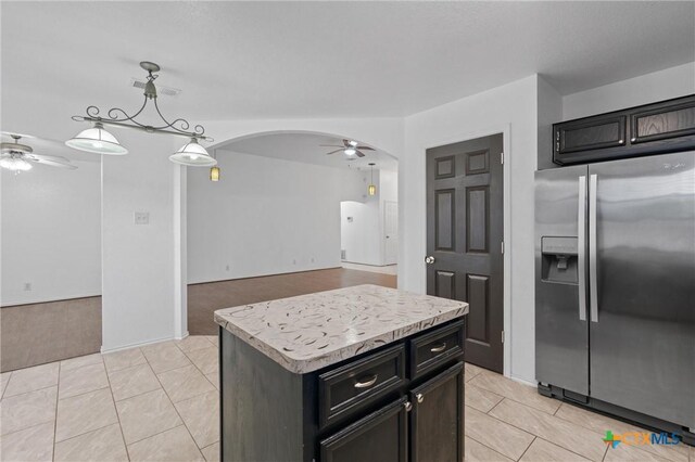 4401 Maggie Dr, Killeen, TX 76549 - kitchen featuring stainless steel fridge with ice dispenser, a ceiling fan, arched walkways, light tile patterned floors, and light countertops