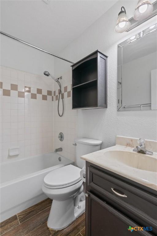 4401 Maggie Dr, Killeen, TX 76549 - full bathroom featuring vanity, washtub / shower combination, wood finished floors, and toilet