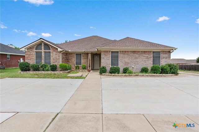 4401 Maggie Dr, Killeen, TX 76549 - view of front of property featuring brick siding, roof with shingles, and central AC unit